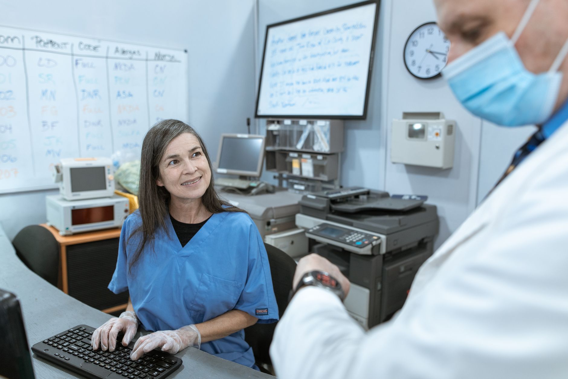 Two healthcare workers talking in a hospital office.