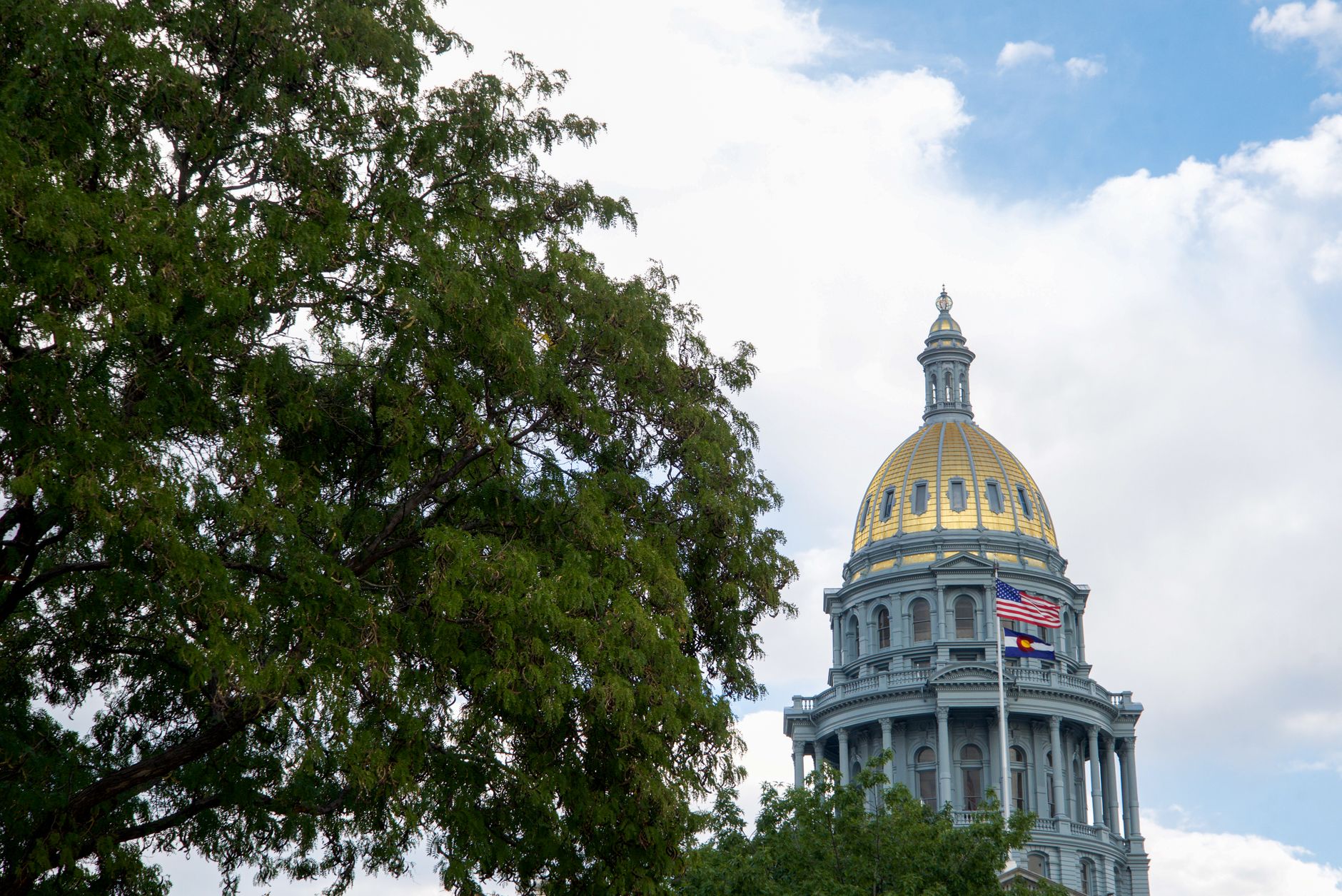 The Colorado State Capitol building in Denver with its gold dome under a clear sky.