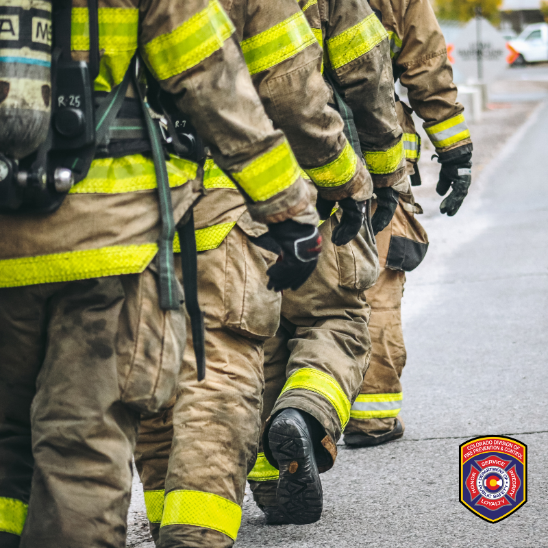 Firefighters in turnout gear walk together in an image shared by the Colorado Division of Fire Prevention and Control alongside its 2026 fire-service needs assessment announcement.