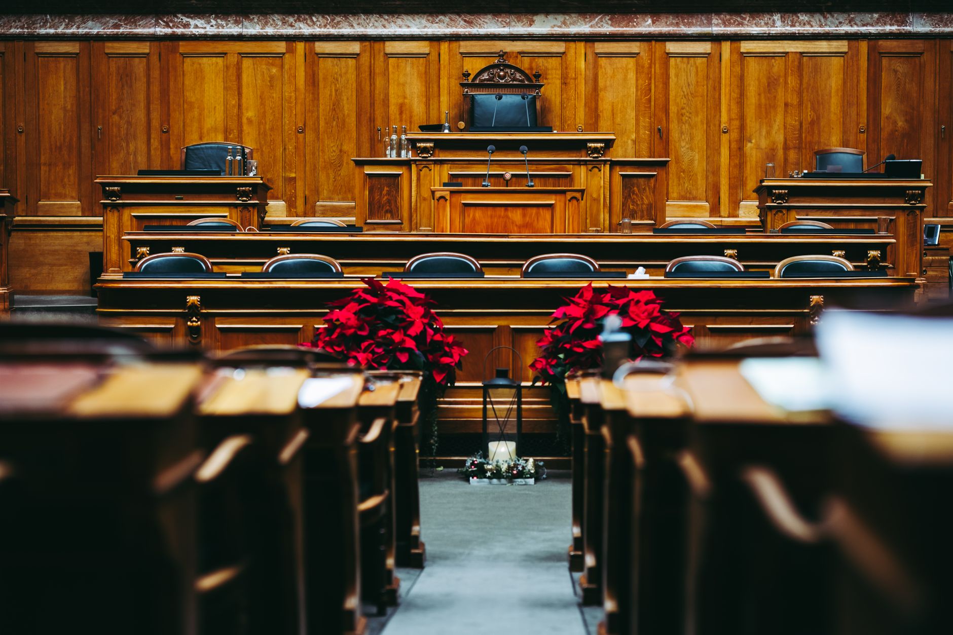Empty courtroom with wooden seating and a judge’s bench.