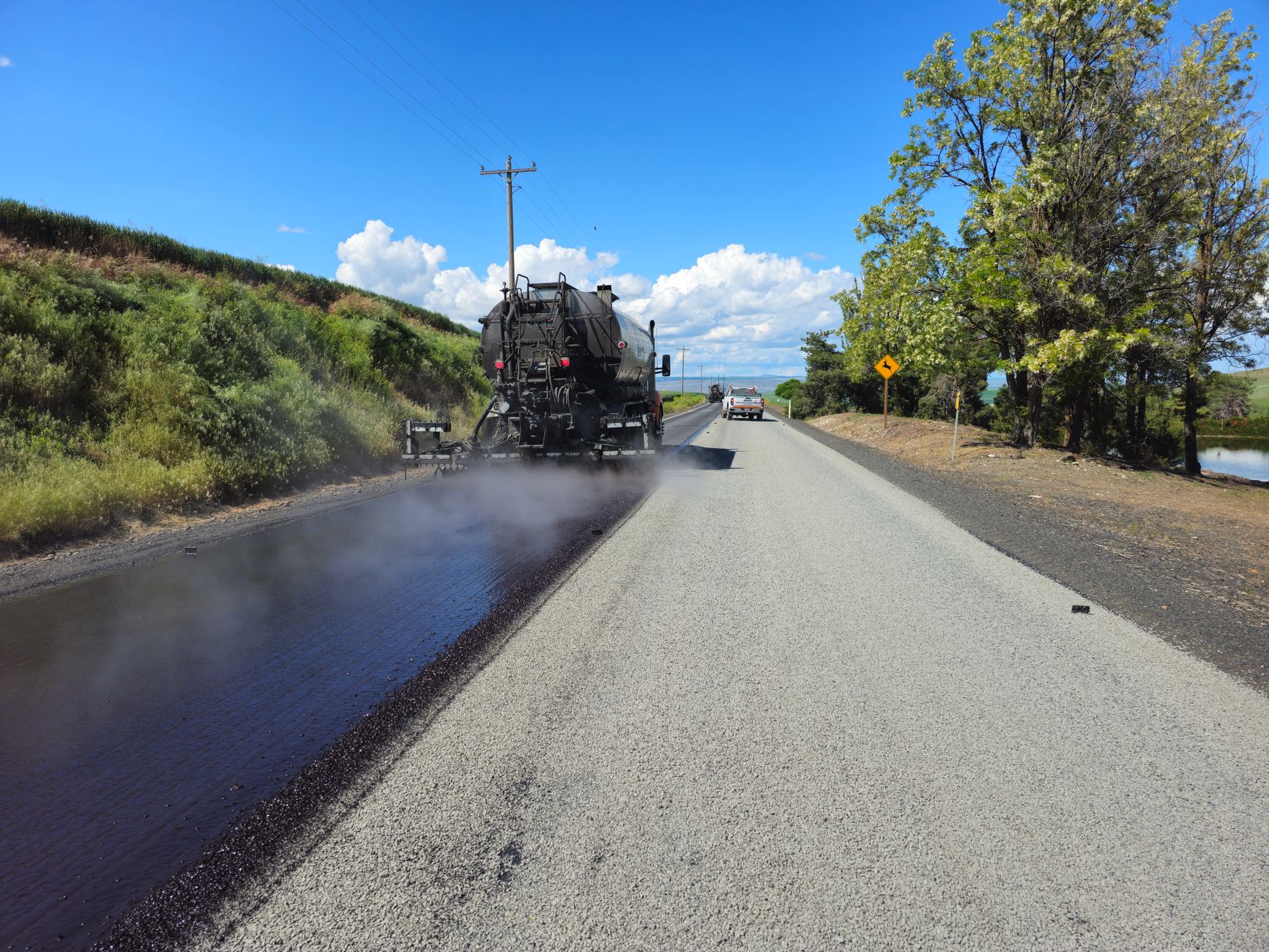 An asphalt paver resurfaces a road.