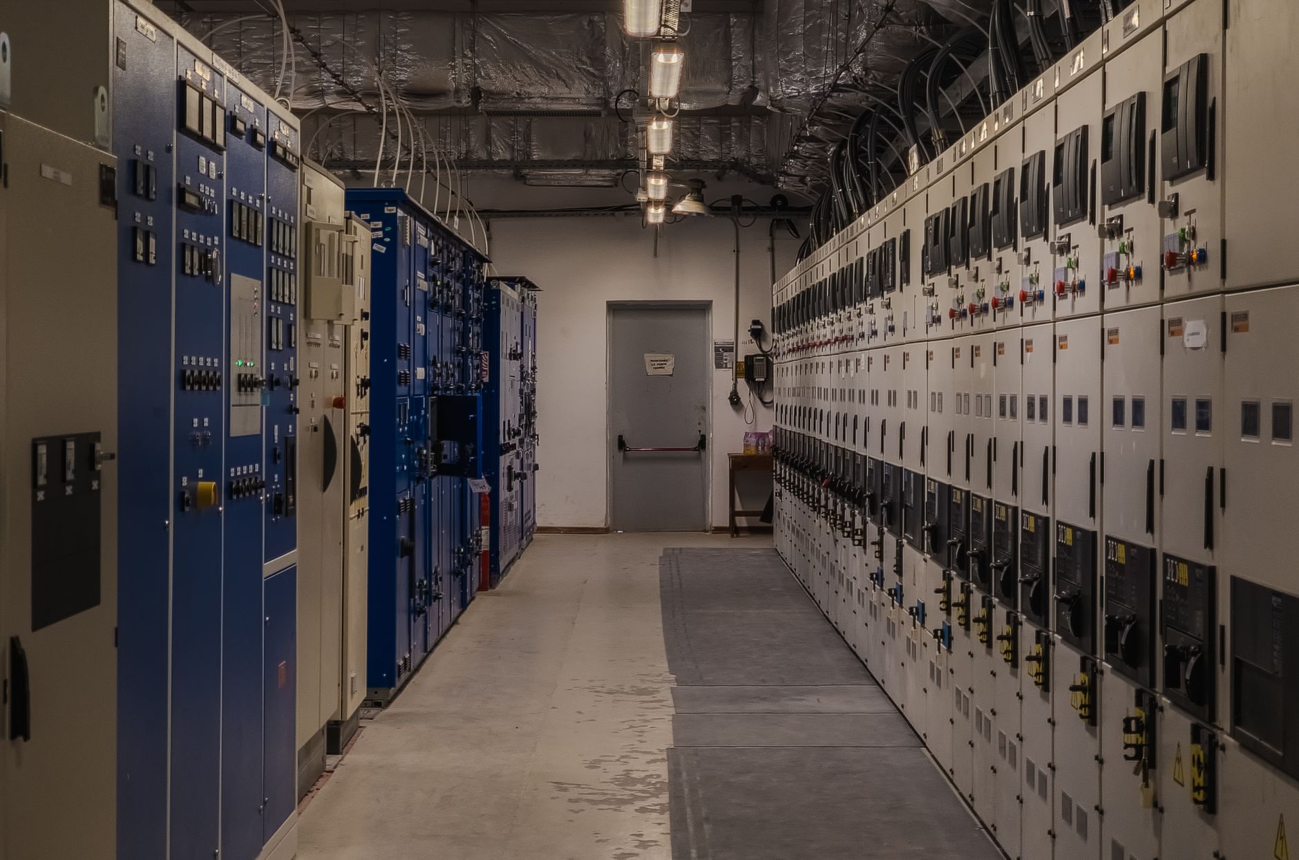 Electrical panels and equipment fill an industrial control room.