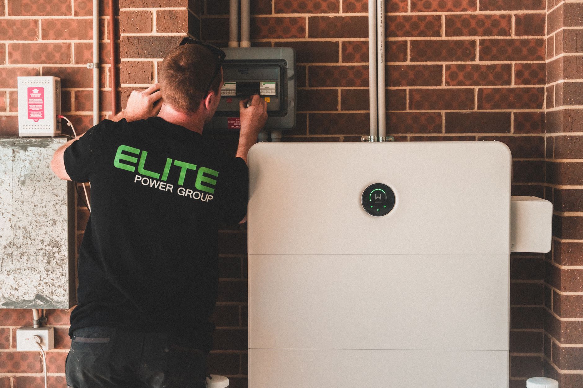 Technician installing a residential battery-storage unit.