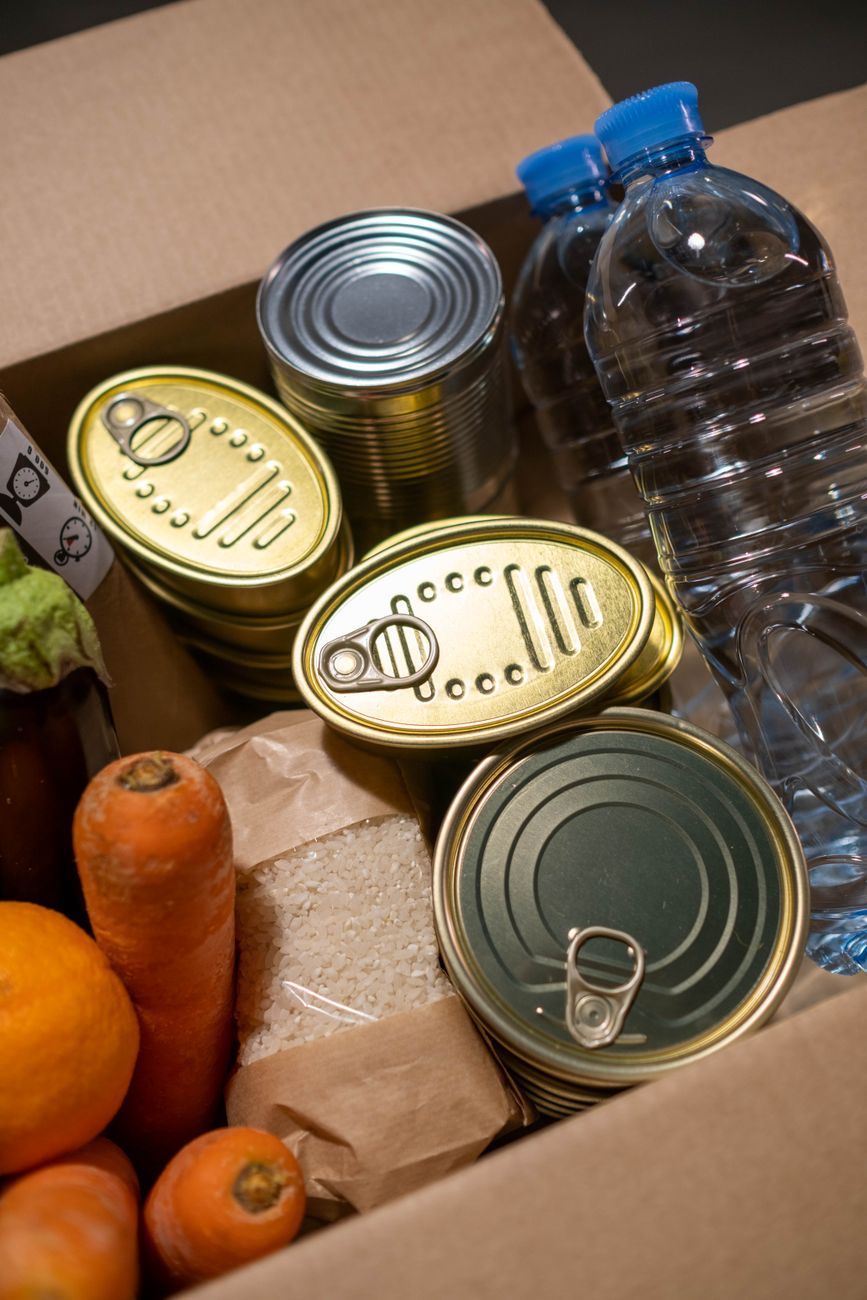 A food-assistance box contains canned goods, bottled water and fresh produce.