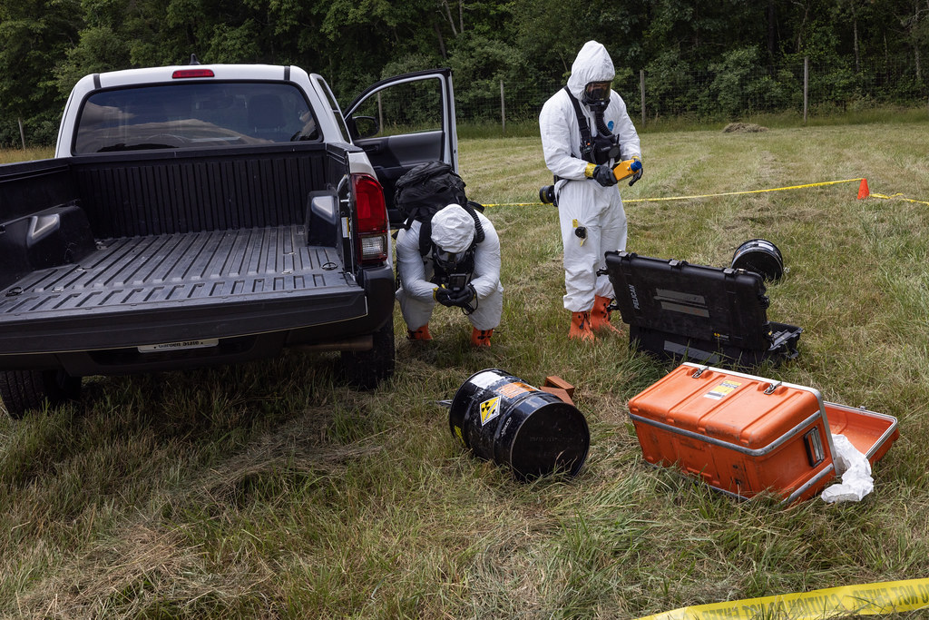 Hazmat personnel work with equipment in the field.