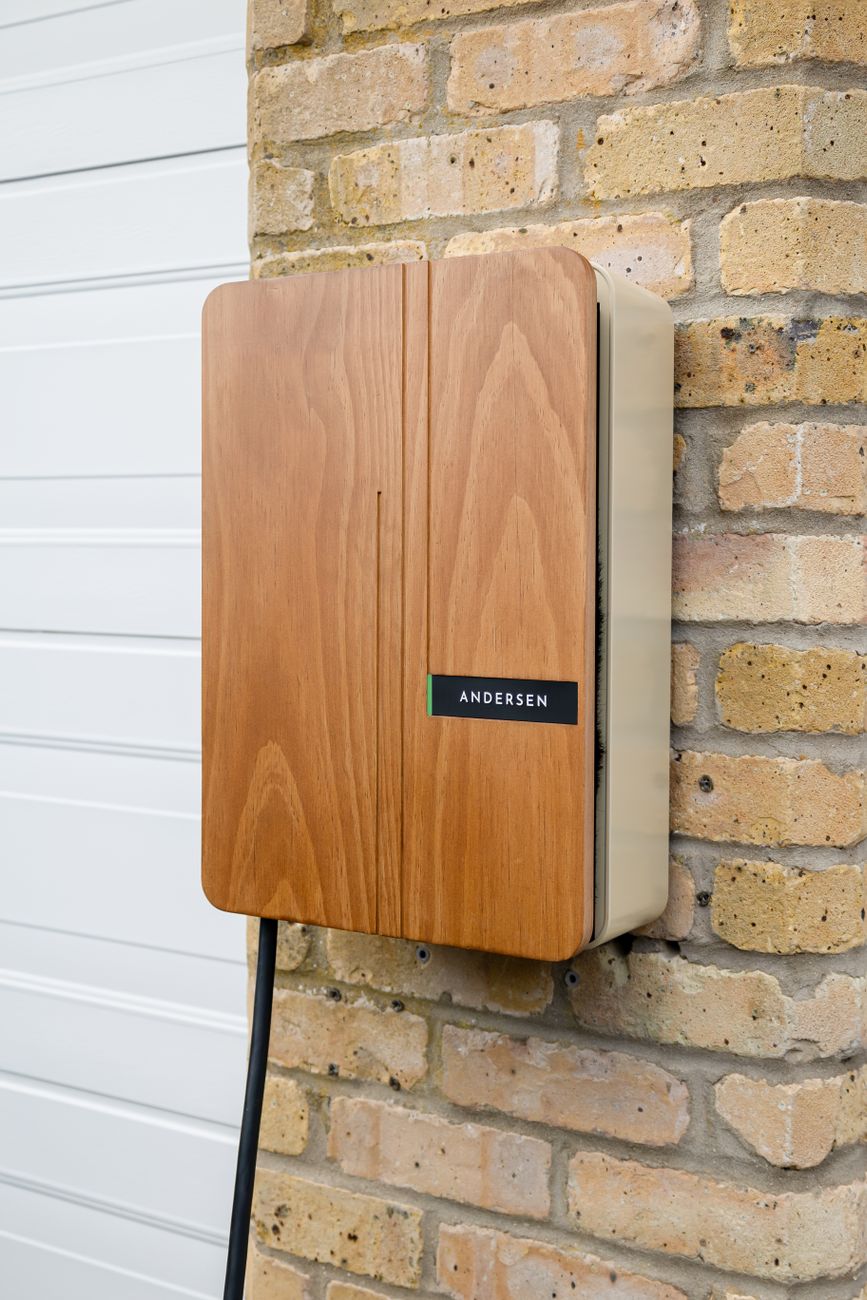 A wall-mounted electric-vehicle charger on a home's exterior.