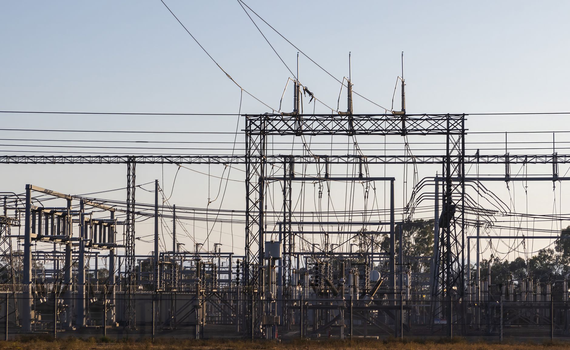 A high-voltage electrical substation with steel structures and power lines.