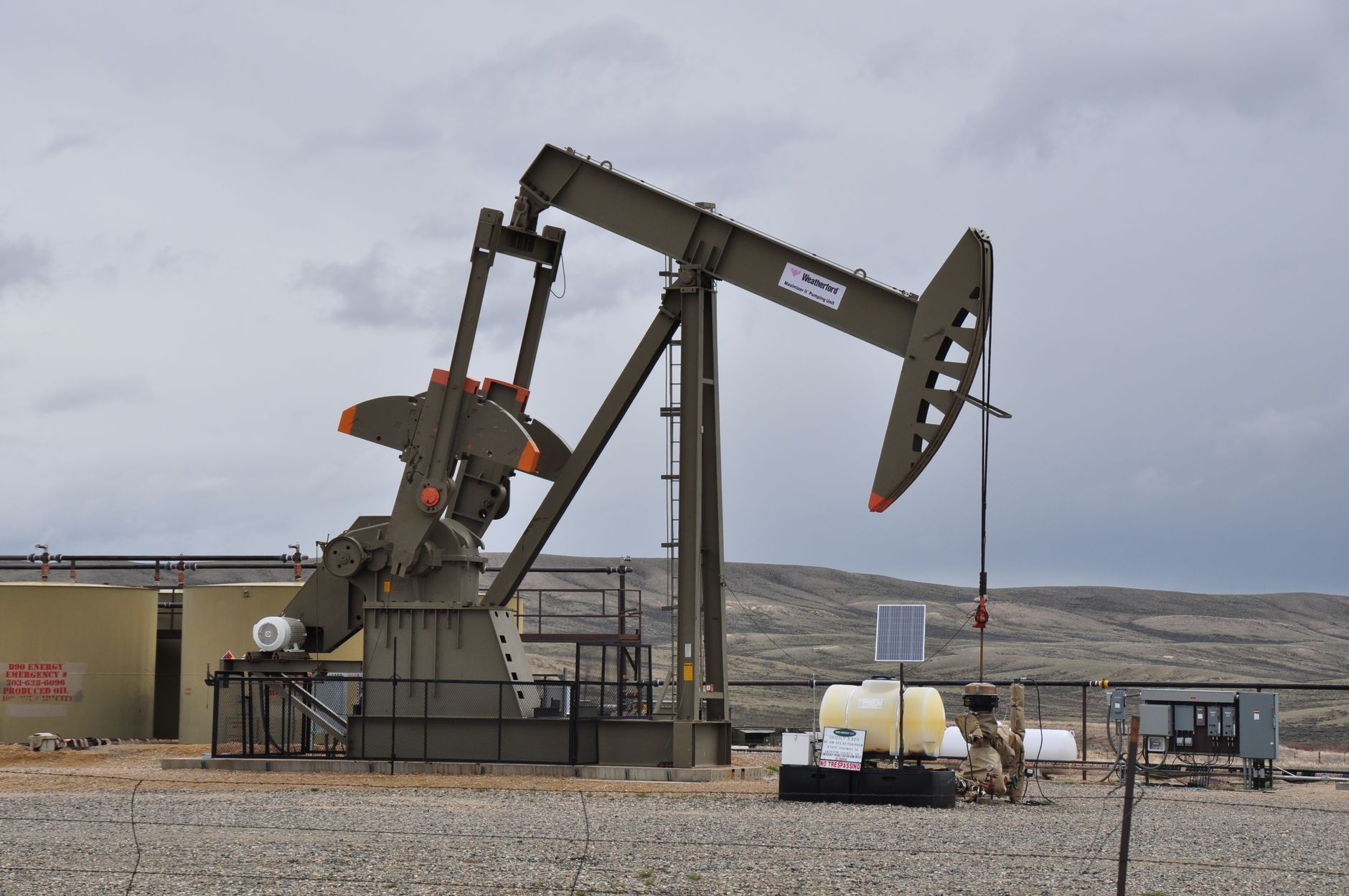 An oil pumpjack and equipment at an industrial site.