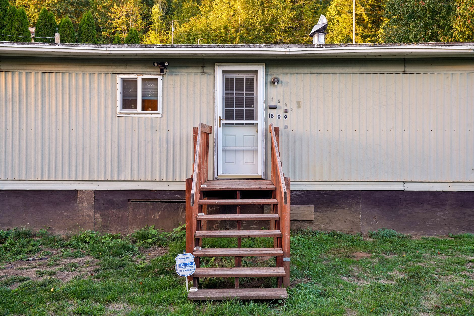A manufactured home with wooden steps at its entrance.