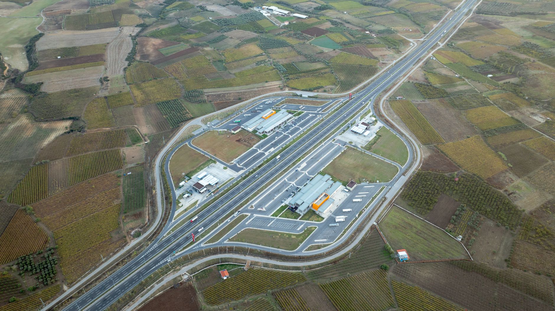 An aerial view of a highway crossing open agricultural fields.