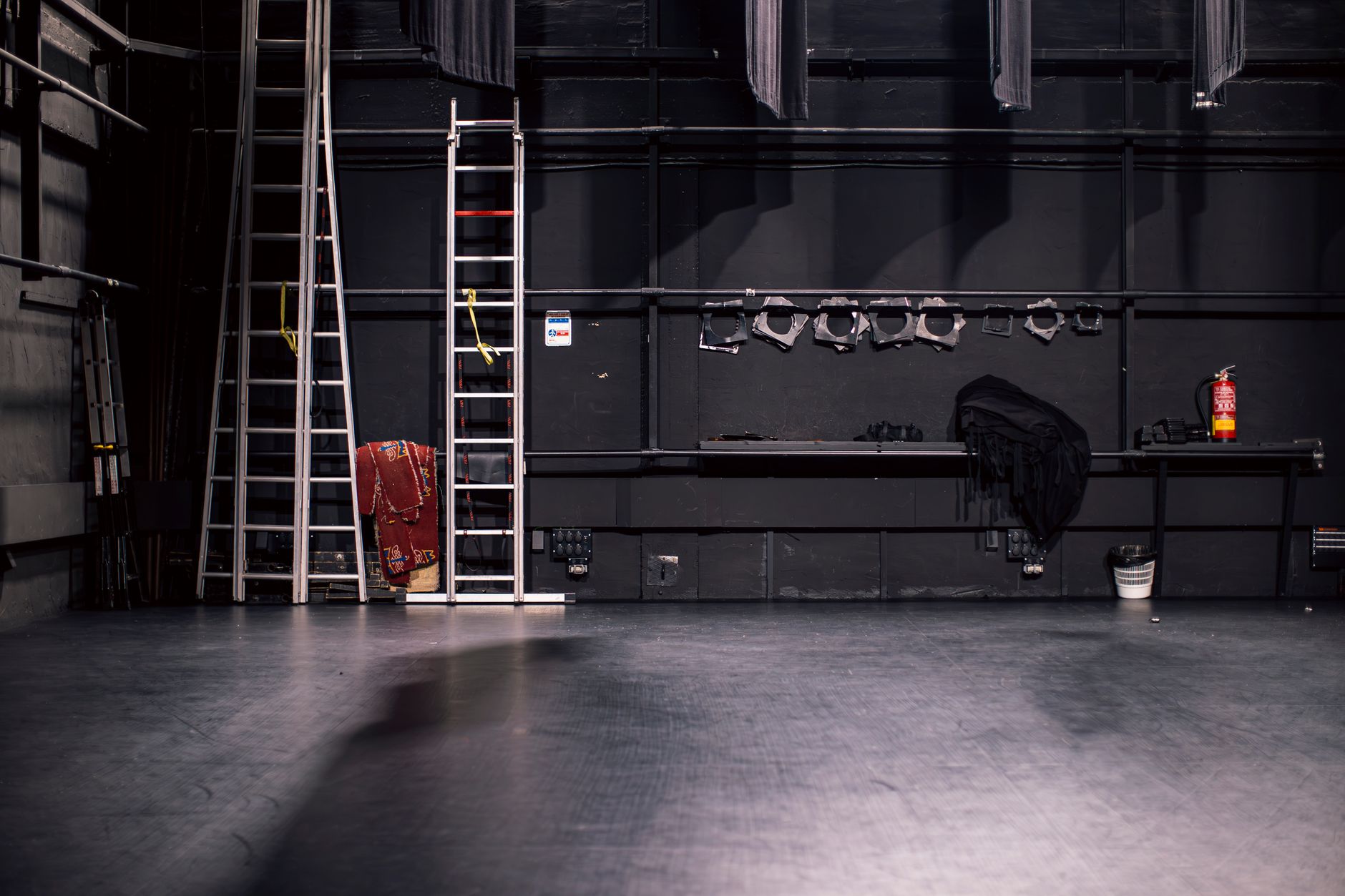 A theater stage with ladders and production equipment.